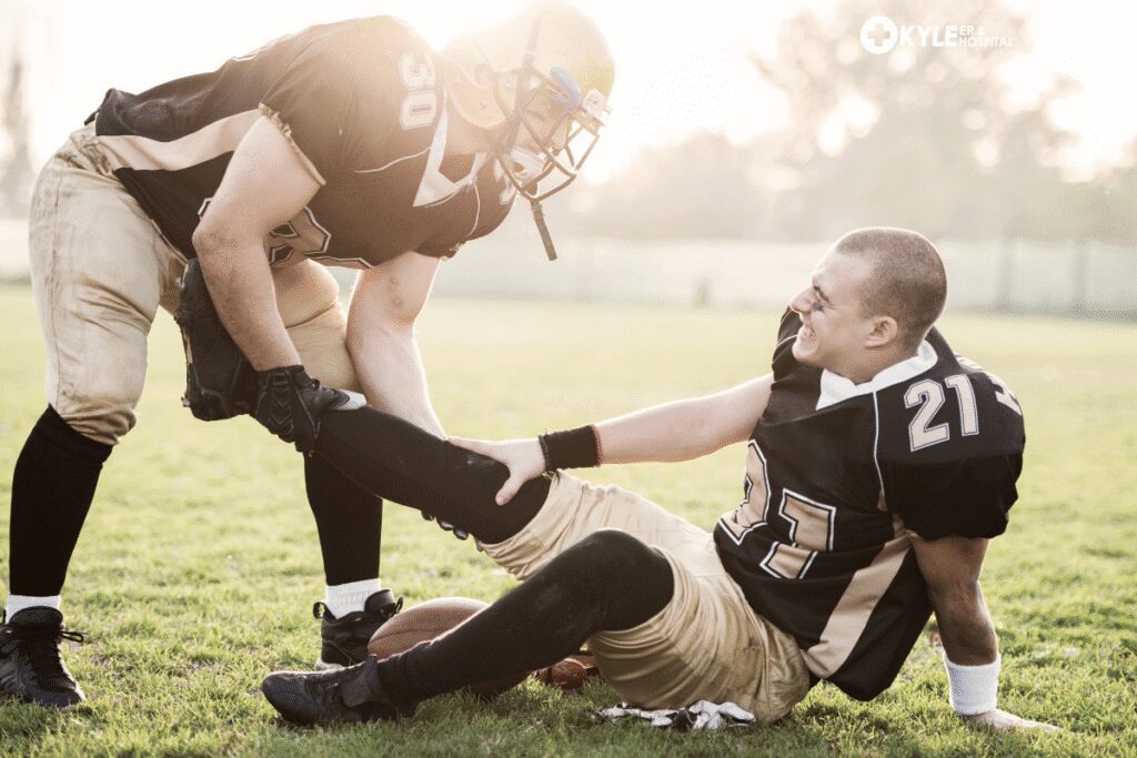 Two football players shaking hands on the field during practice.