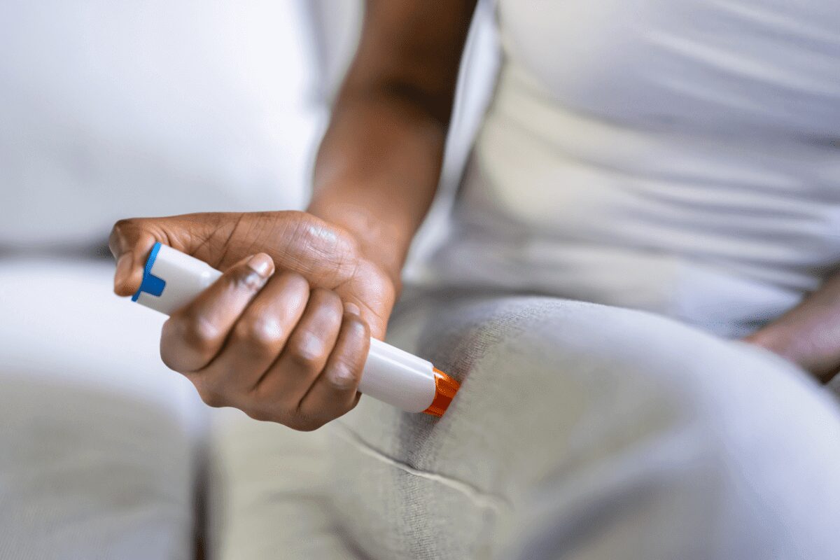 Person holding an insulin pen for diabetes management.