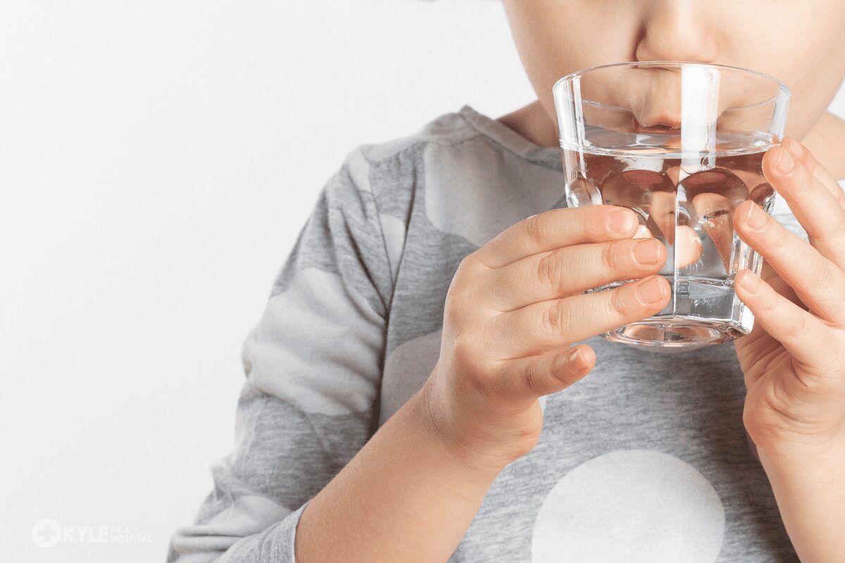 Child drinking a glass of water.