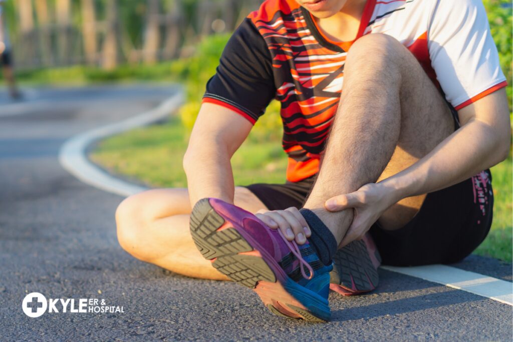 Person sitting on pavement clutching injured ankle